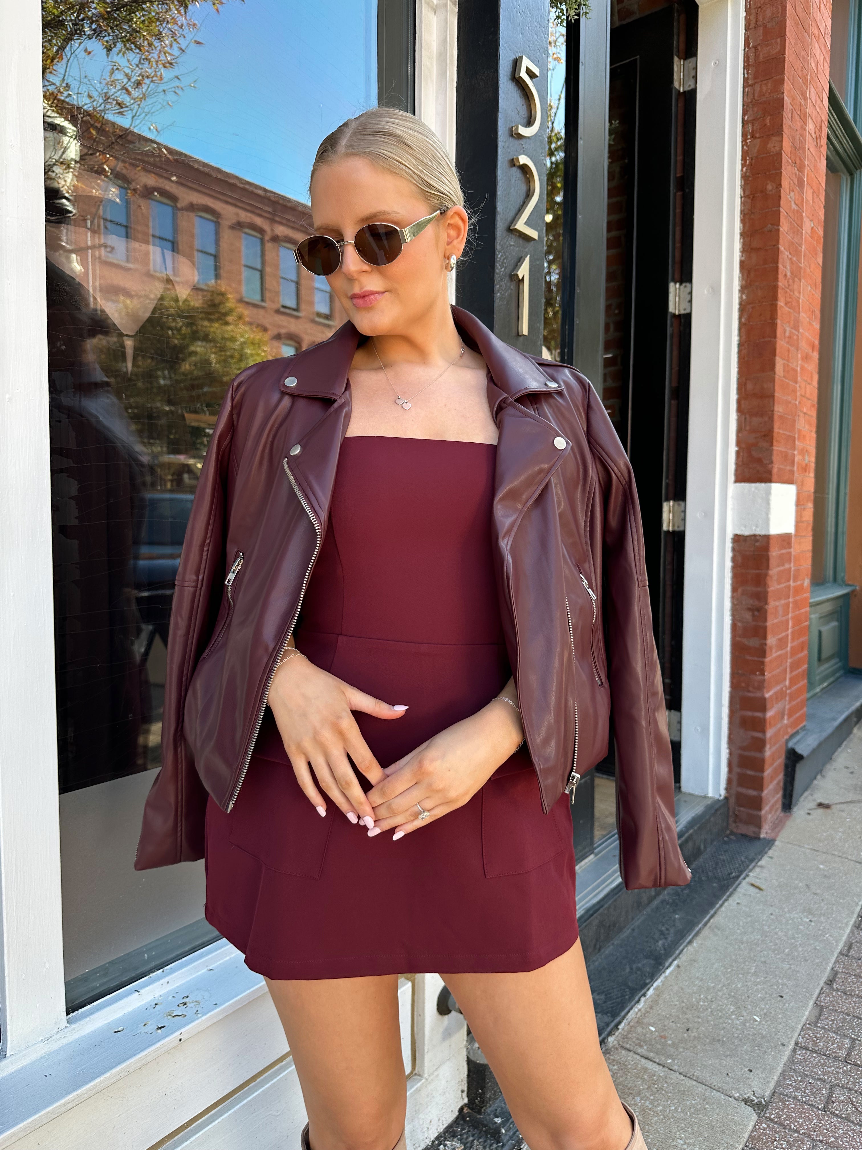 Woman wearing rose tailored mini dress with square neckline and front pockets.