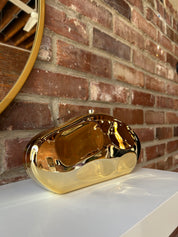 Gold hardshell clutch bag with detachable chain.