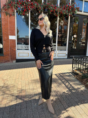 Woman wearing black leather midi skirt with slit up the back.