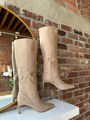 Tan suede knee-high boots with gold zipper hardware.