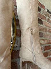 Tan suede knee-high boots with gold zipper hardware.