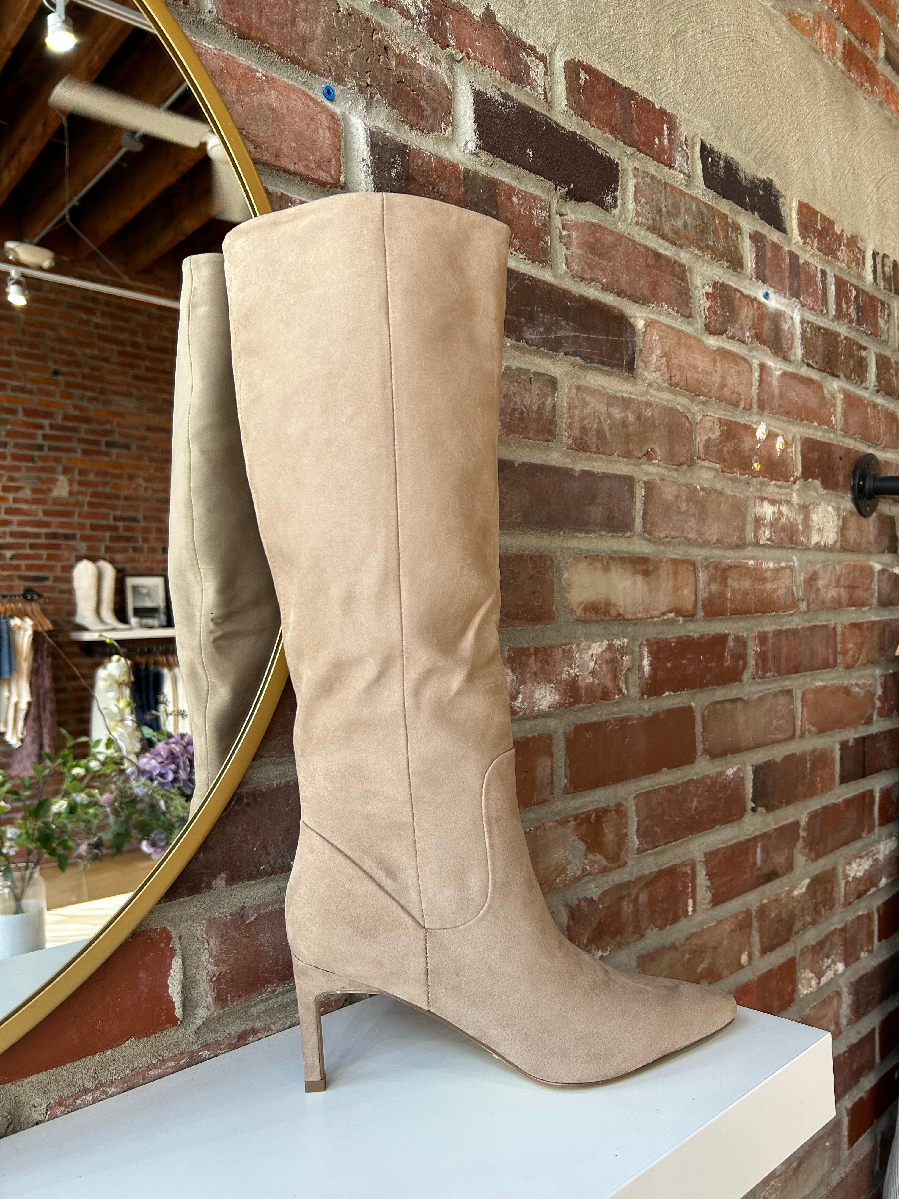 Tan suede knee-high boots with gold zipper hardware.