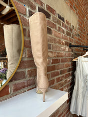 Tan suede knee-high boots with gold zipper hardware.