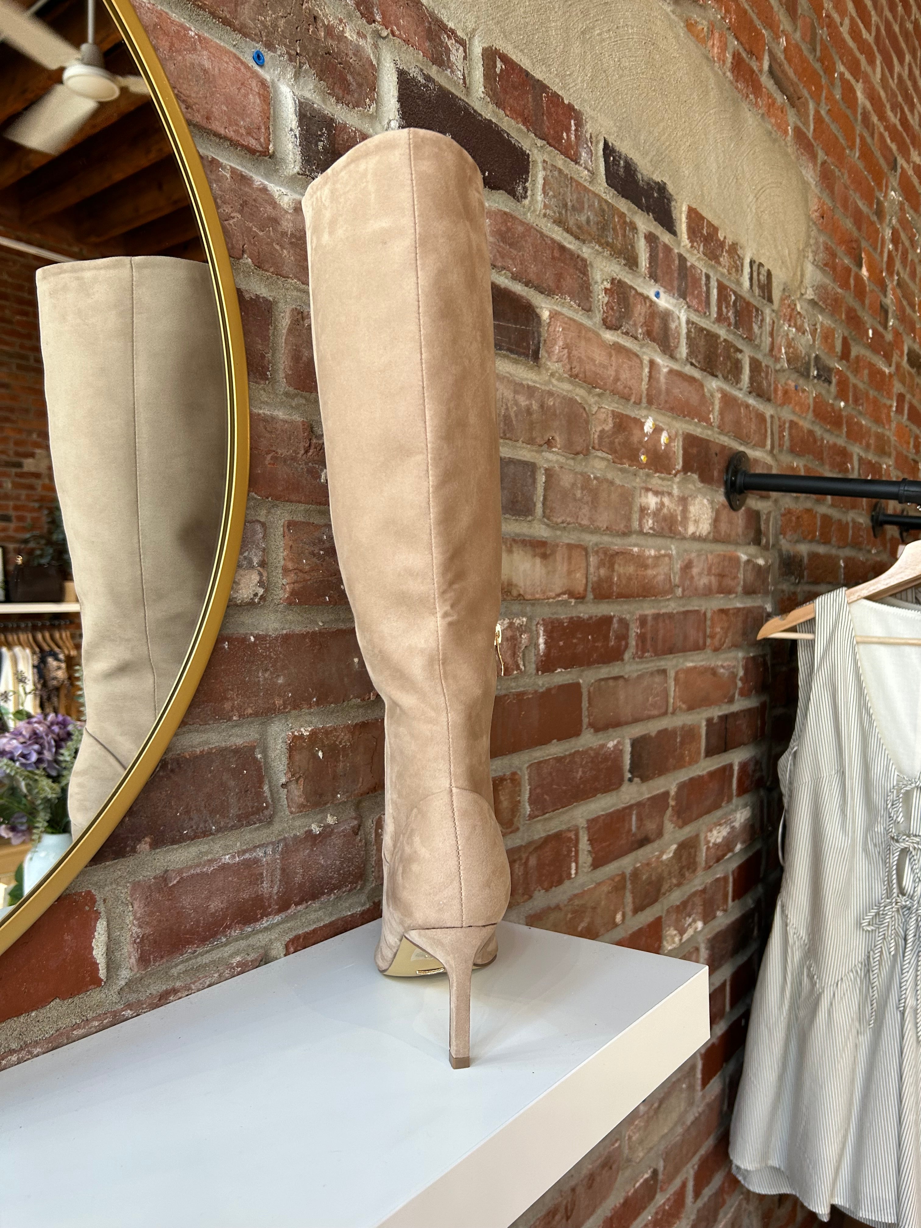 Tan suede knee-high boots with gold zipper hardware.