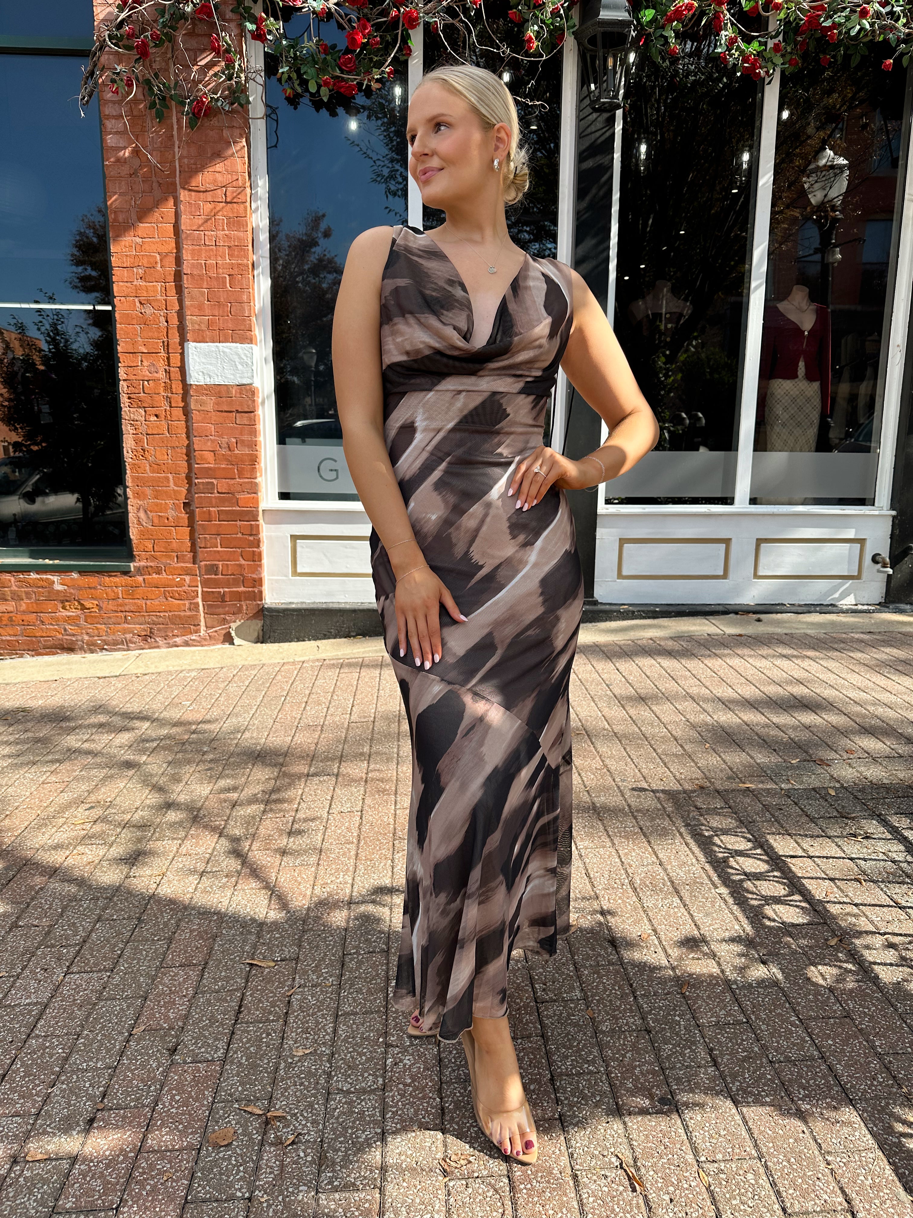 Woman wearing brown abstract pattern mesh midi dress with cowl neck and open back.