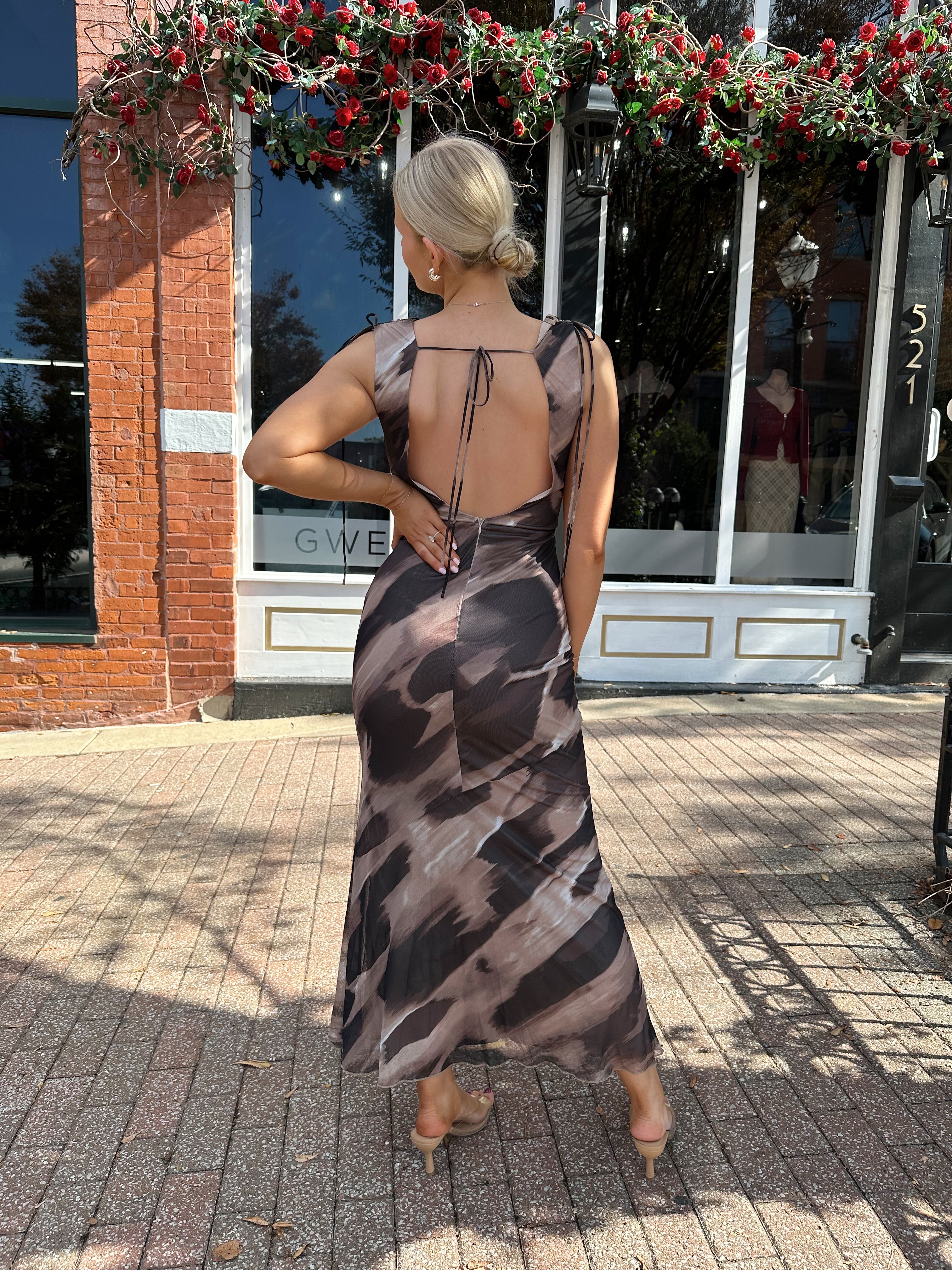 Woman wearing brown abstract pattern mesh midi dress with cowl neck and open back.