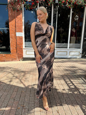 Woman wearing brown abstract pattern mesh midi dress with cowl neck and open back.