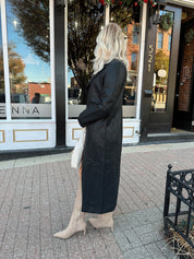 Woman wearing black tailored trench coat and knit sweater mini dress.