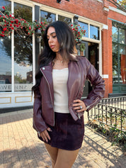 Woman wearing burgundy matte leather jacket with burgundy mini skort.