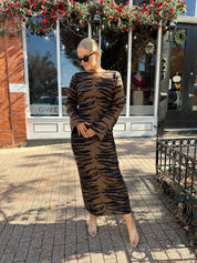 Woman wearing brown zebra print long sleeve sweater dress.