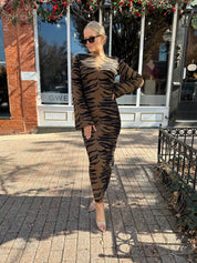 Woman wearing brown zebra print long sleeve sweater dress.
