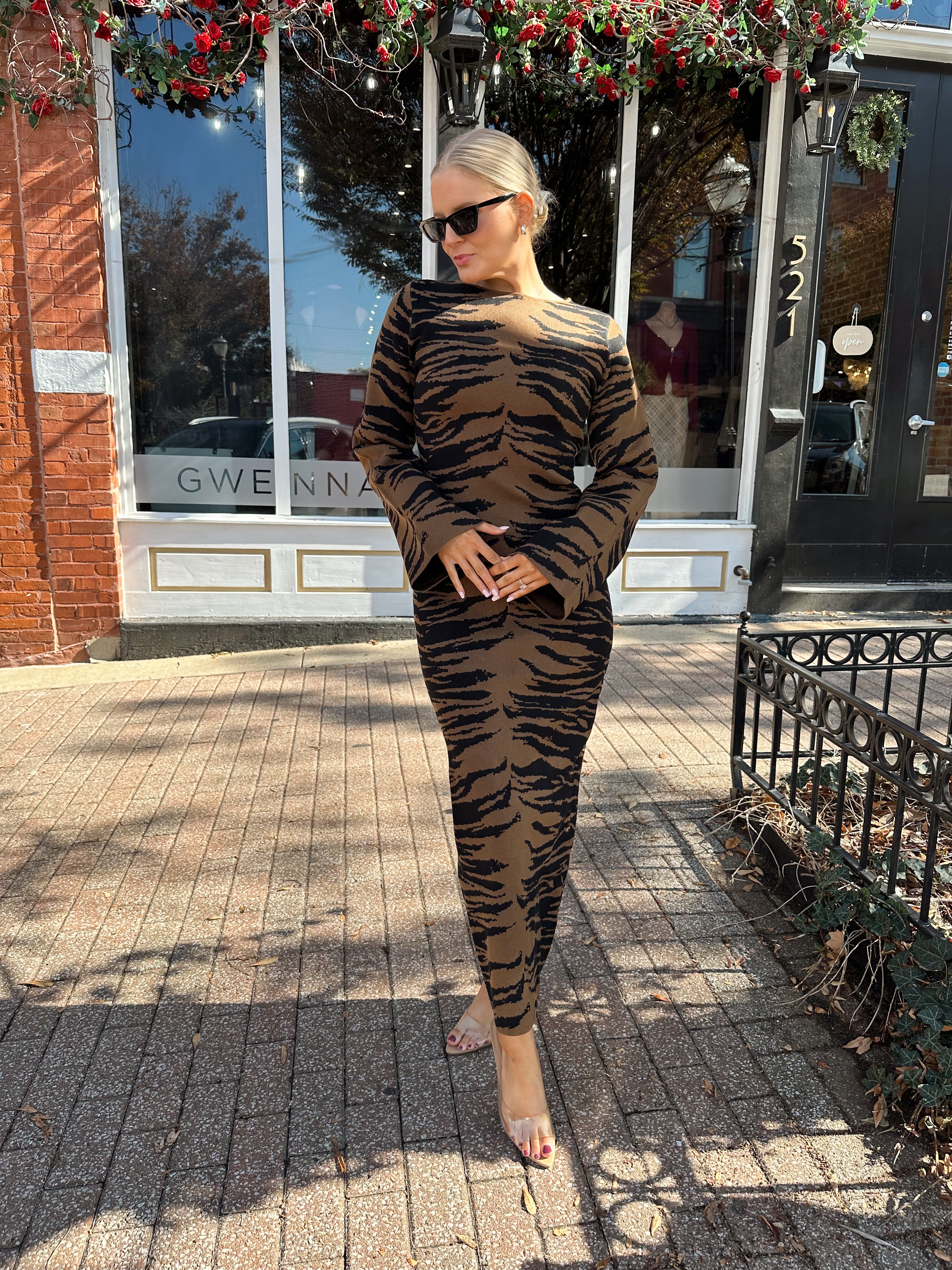 Woman wearing brown zebra print long sleeve sweater dress.