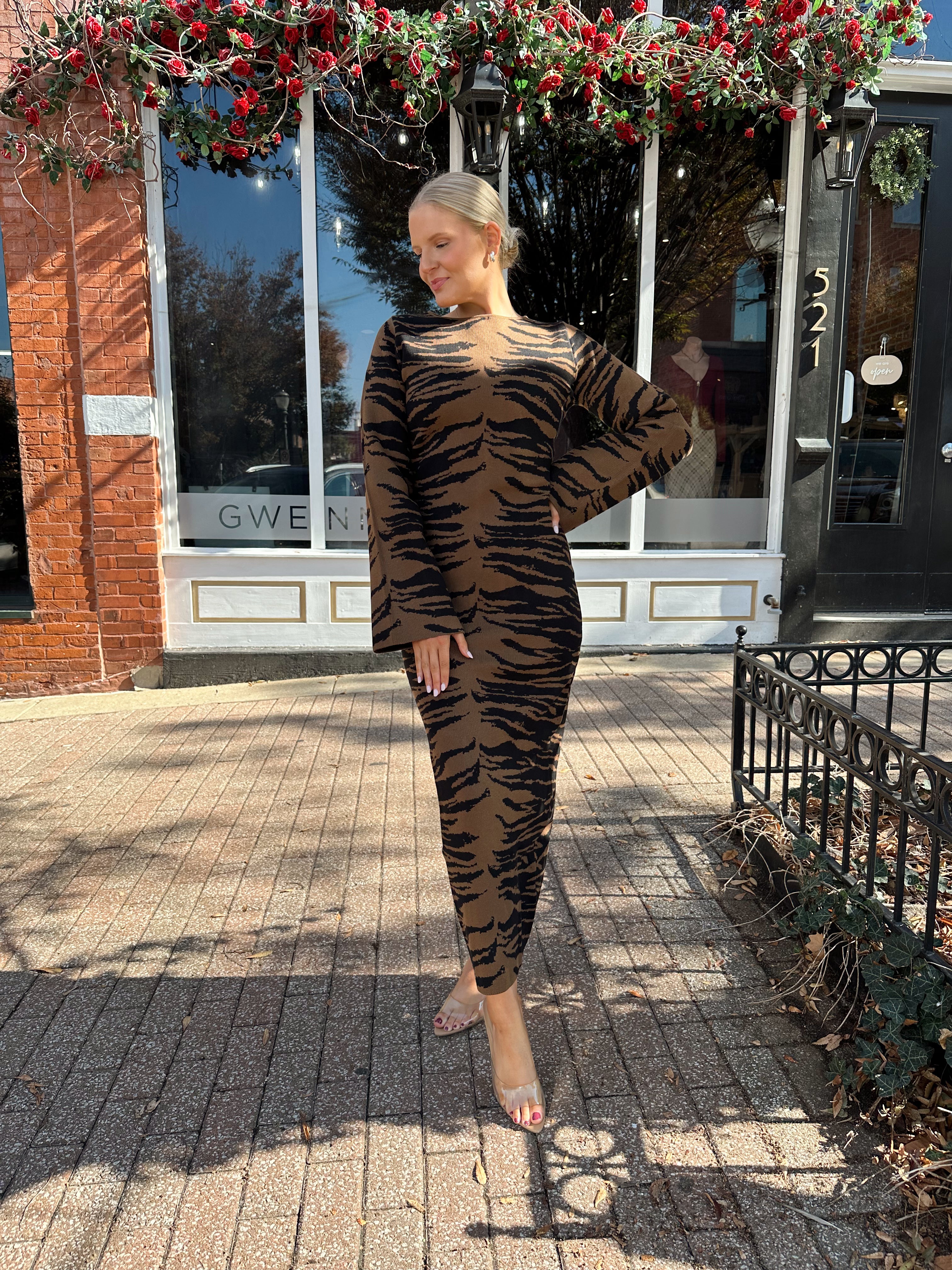 Woman wearing brown zebra print long sleeve sweater dress.