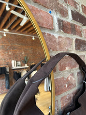 Dark brown suede shoulder bag with magnetic closure.