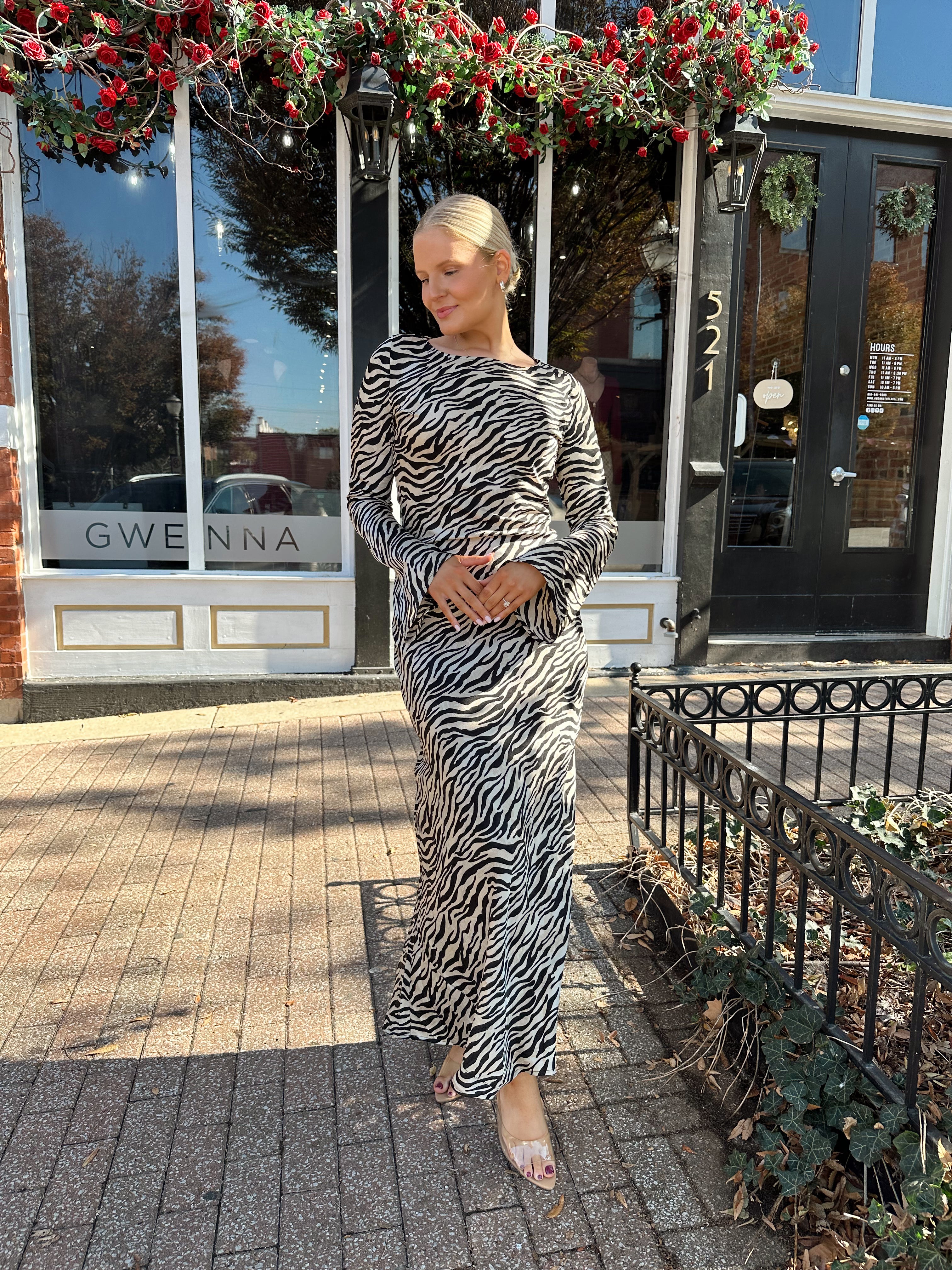 Woman wearing long sleeve zebra print maxi dress with wide sleeve.
