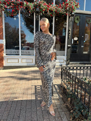 Woman wearing long sleeve zebra print maxi dress with wide sleeve.