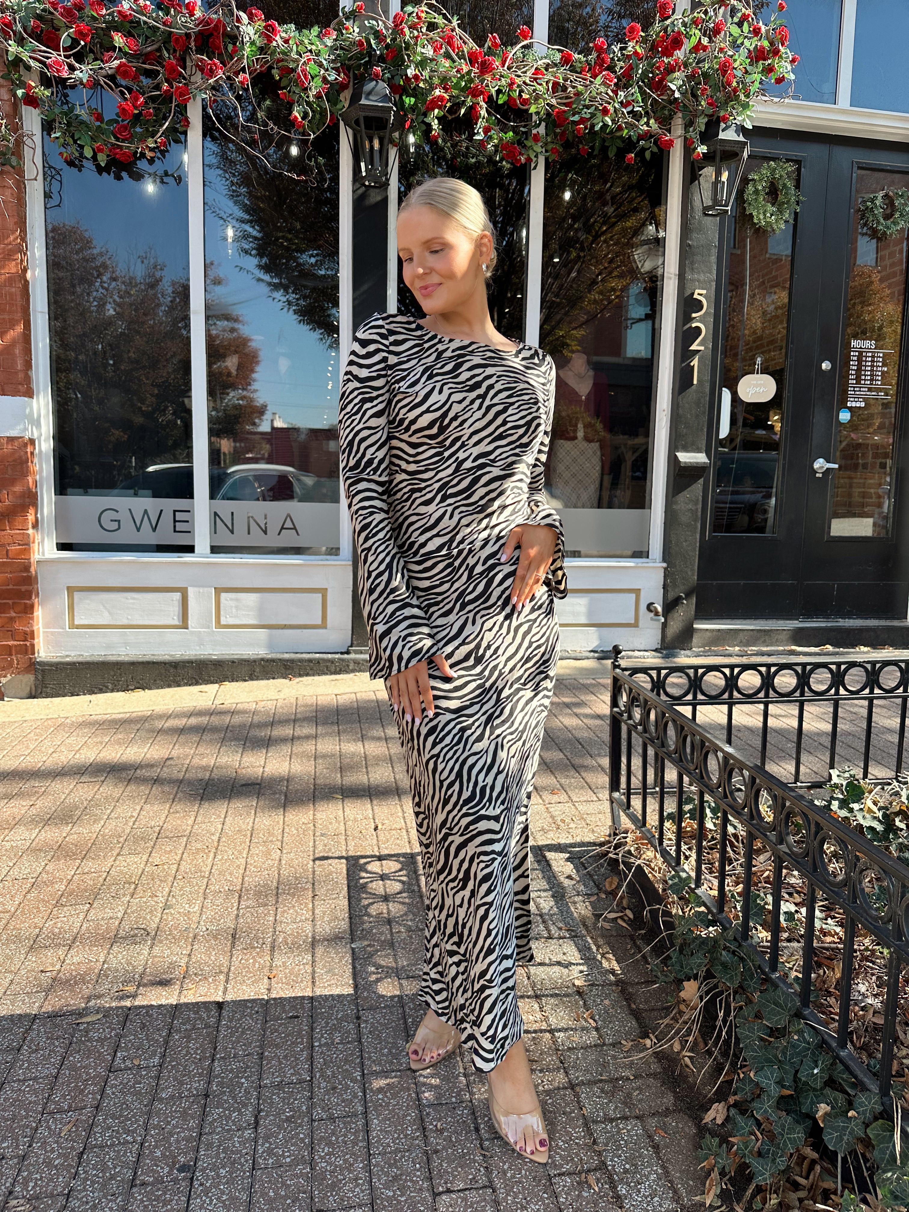 Woman wearing long sleeve zebra print maxi dress with wide sleeve.