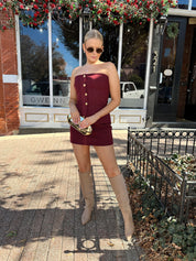 Woman wearing burgundy two piece set with gold button closure.