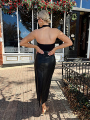 Woman wearing black mesh cowl, halter neck top.
