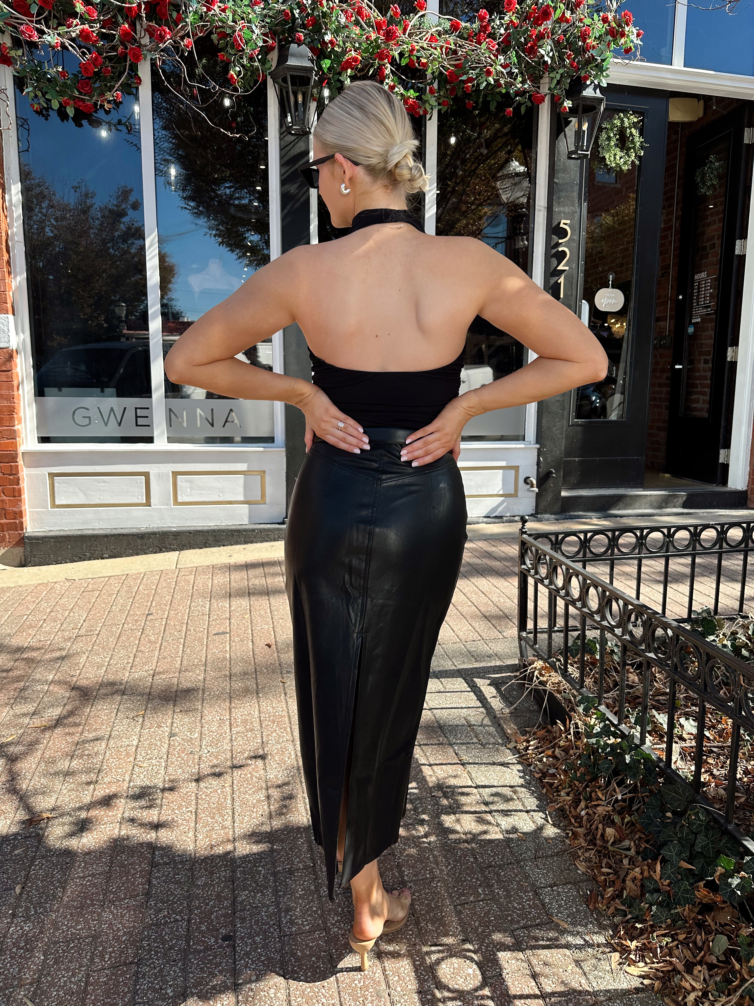 Woman wearing black mesh cowl, halter neck top.