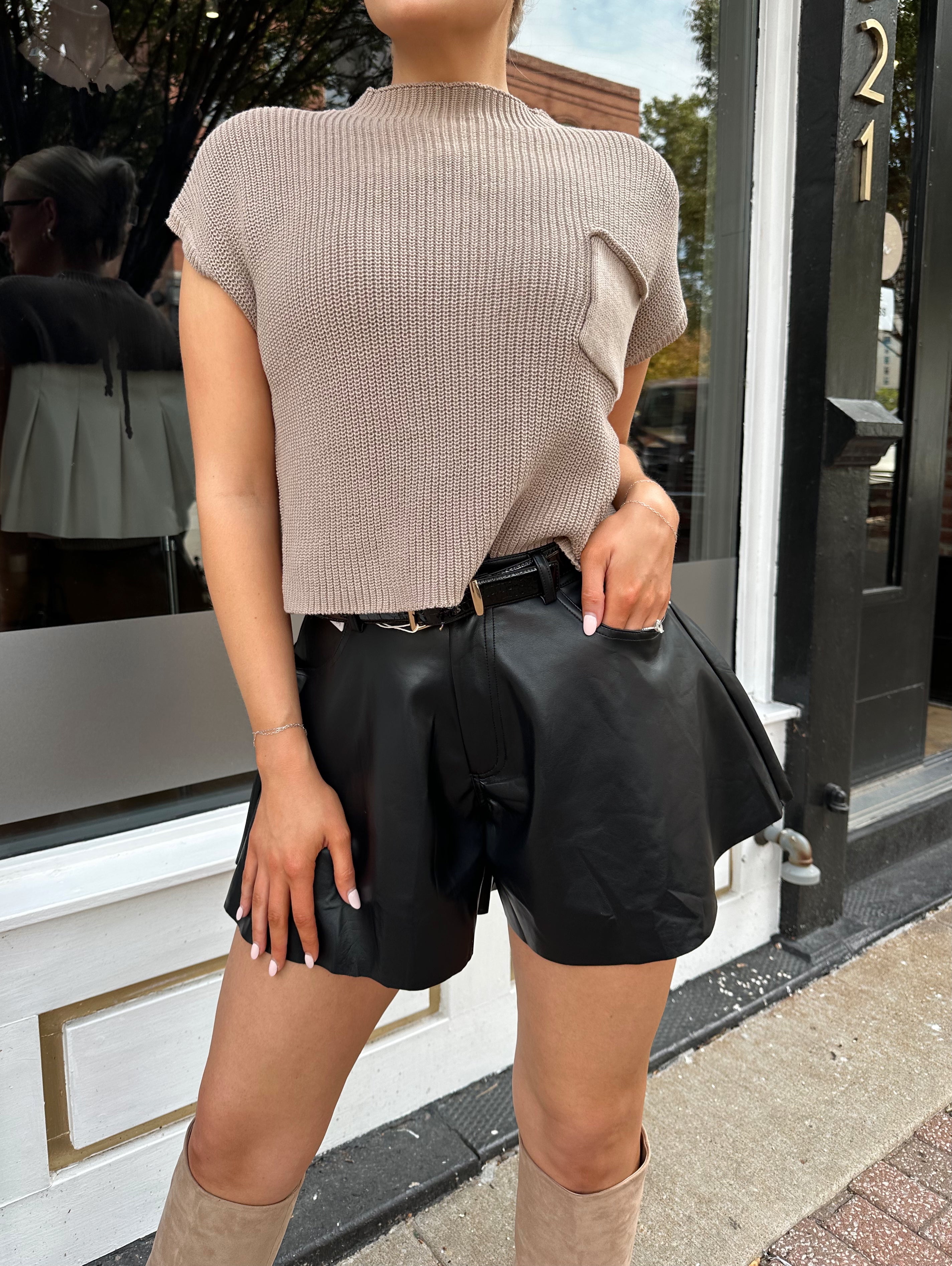 Black leather pleated short with oversized fit, skirt-like silhouette, and functional pockets