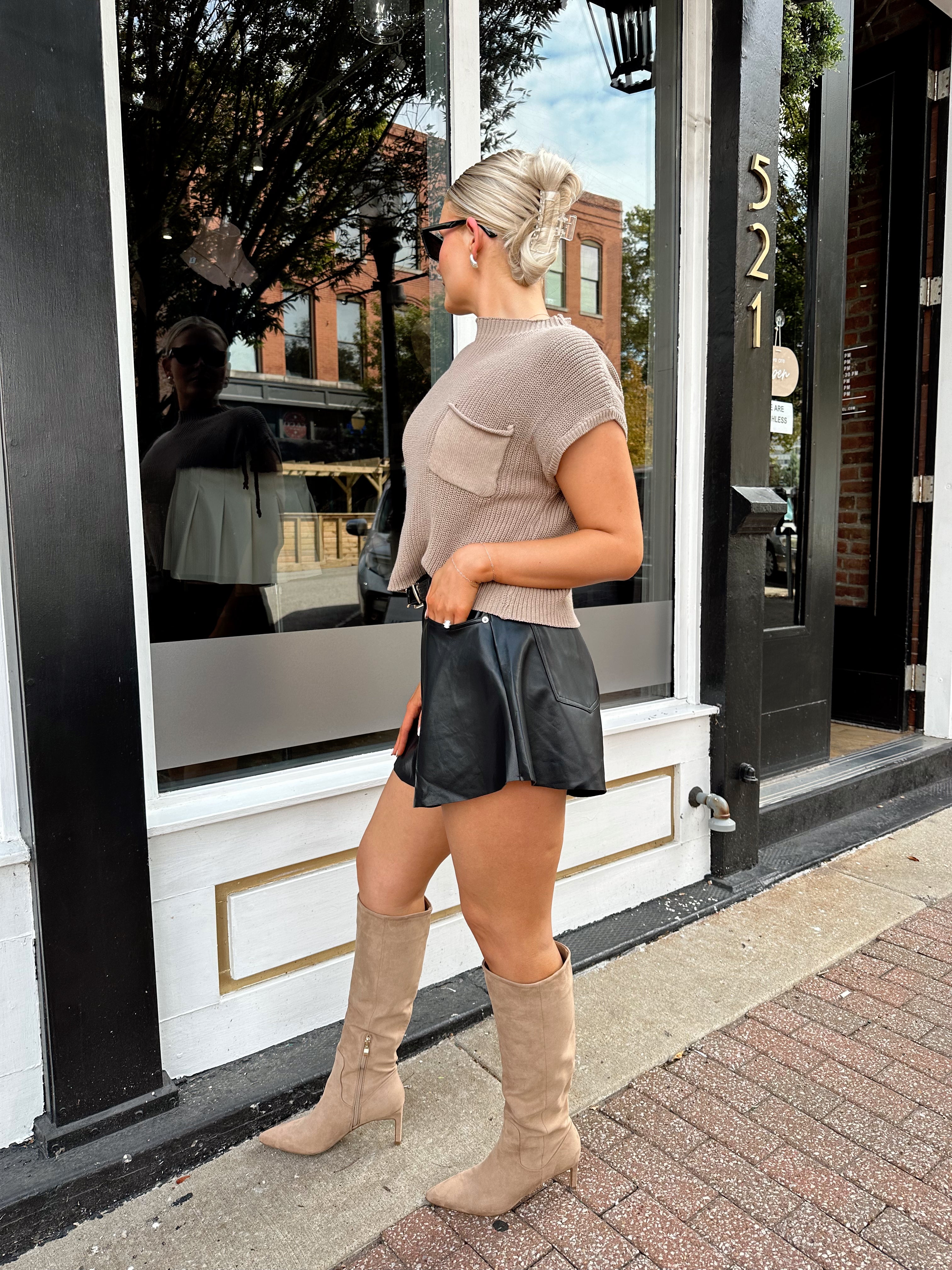 Black leather pleated short with oversized fit, skirt-like silhouette, and functional pockets