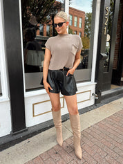 Black leather pleated short with oversized fit, skirt-like silhouette, and functional pockets