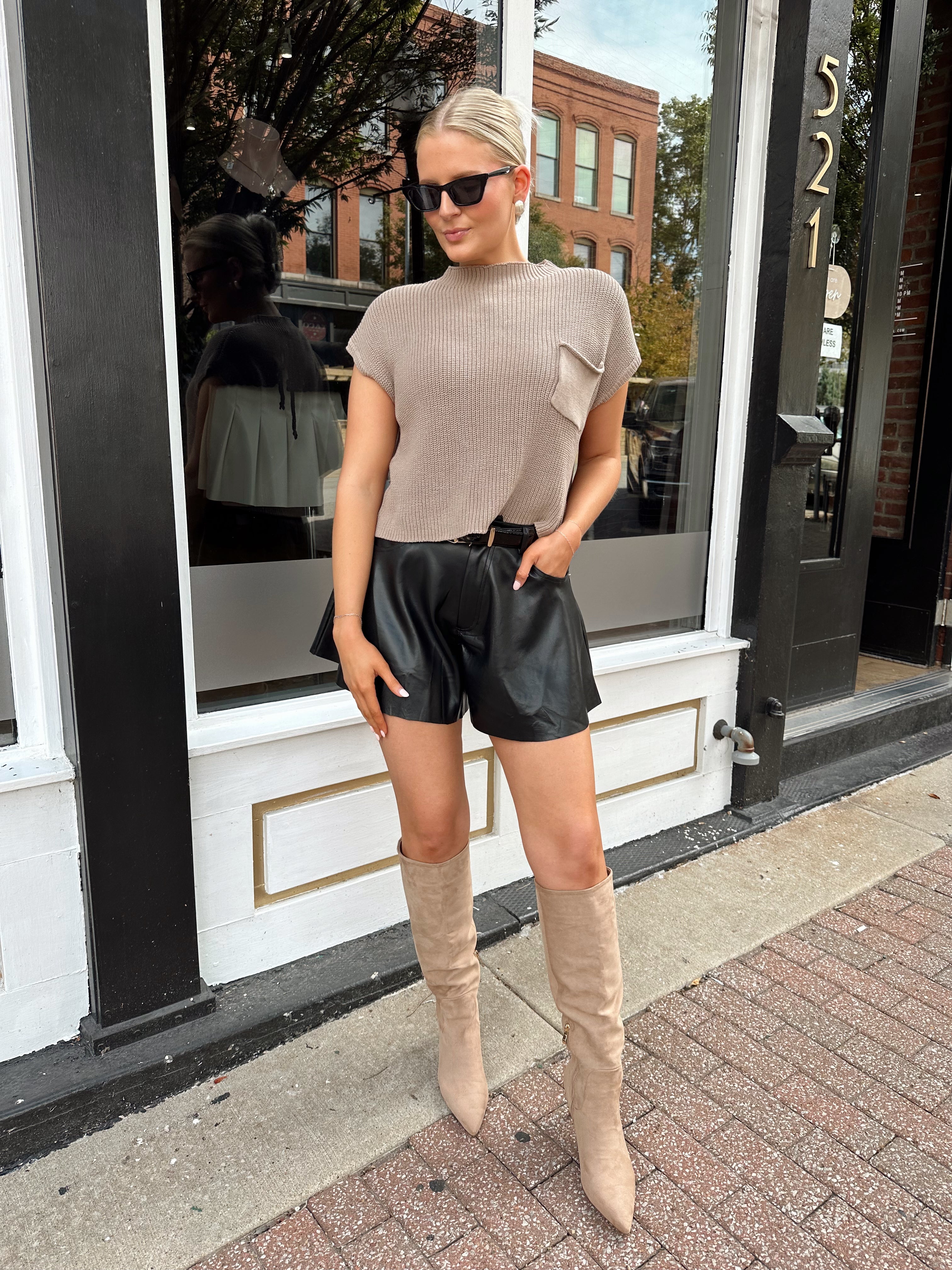 Black leather pleated short with oversized fit, skirt-like silhouette, and functional pockets