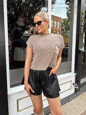 Black leather pleated short with oversized fit, skirt-like silhouette, and functional pockets