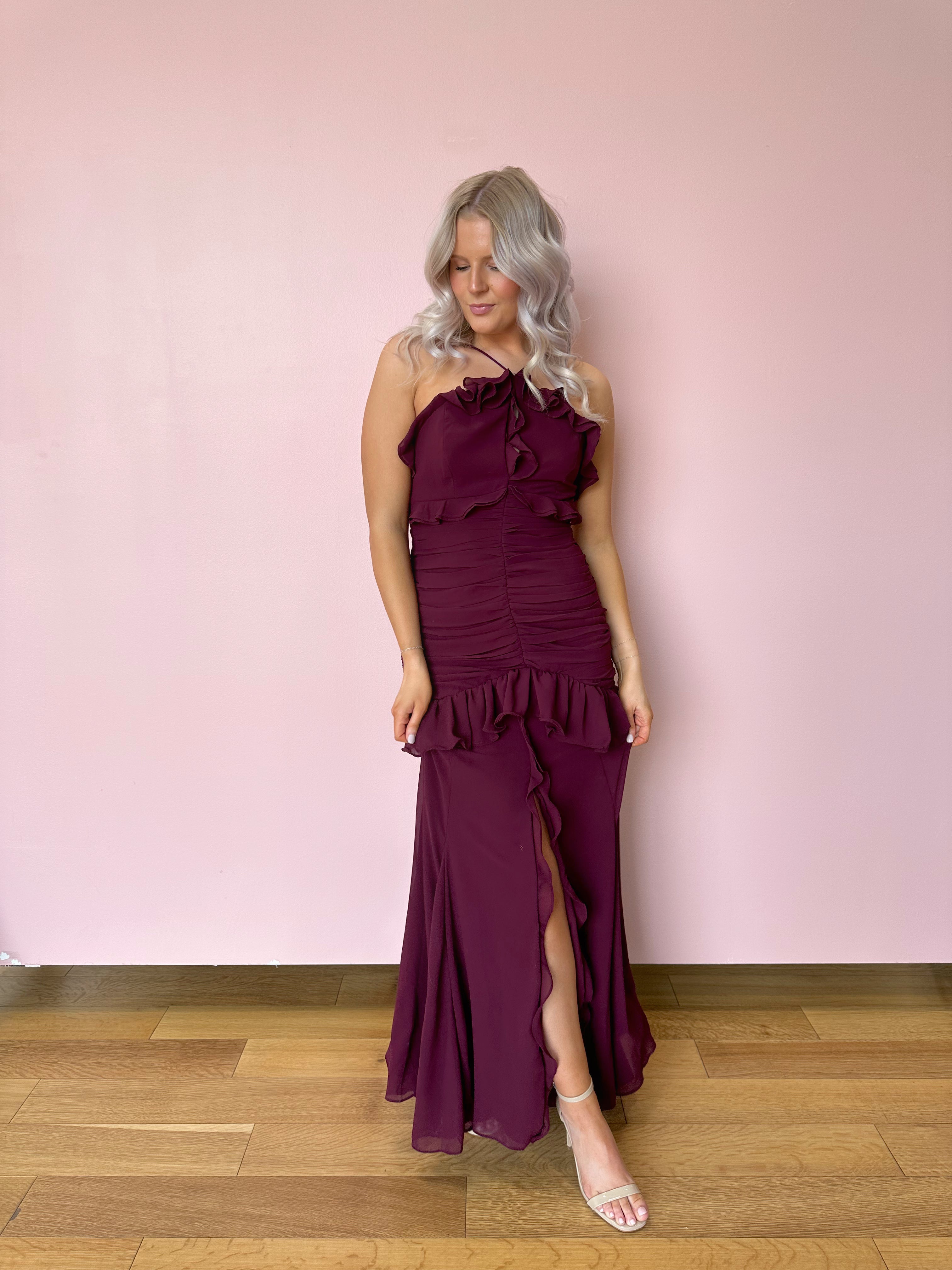 Burgundy formal maxi dress with ruffle detailing and slit up the front. 