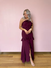 Burgundy formal maxi dress with ruffle detailing and slit up the front. 
