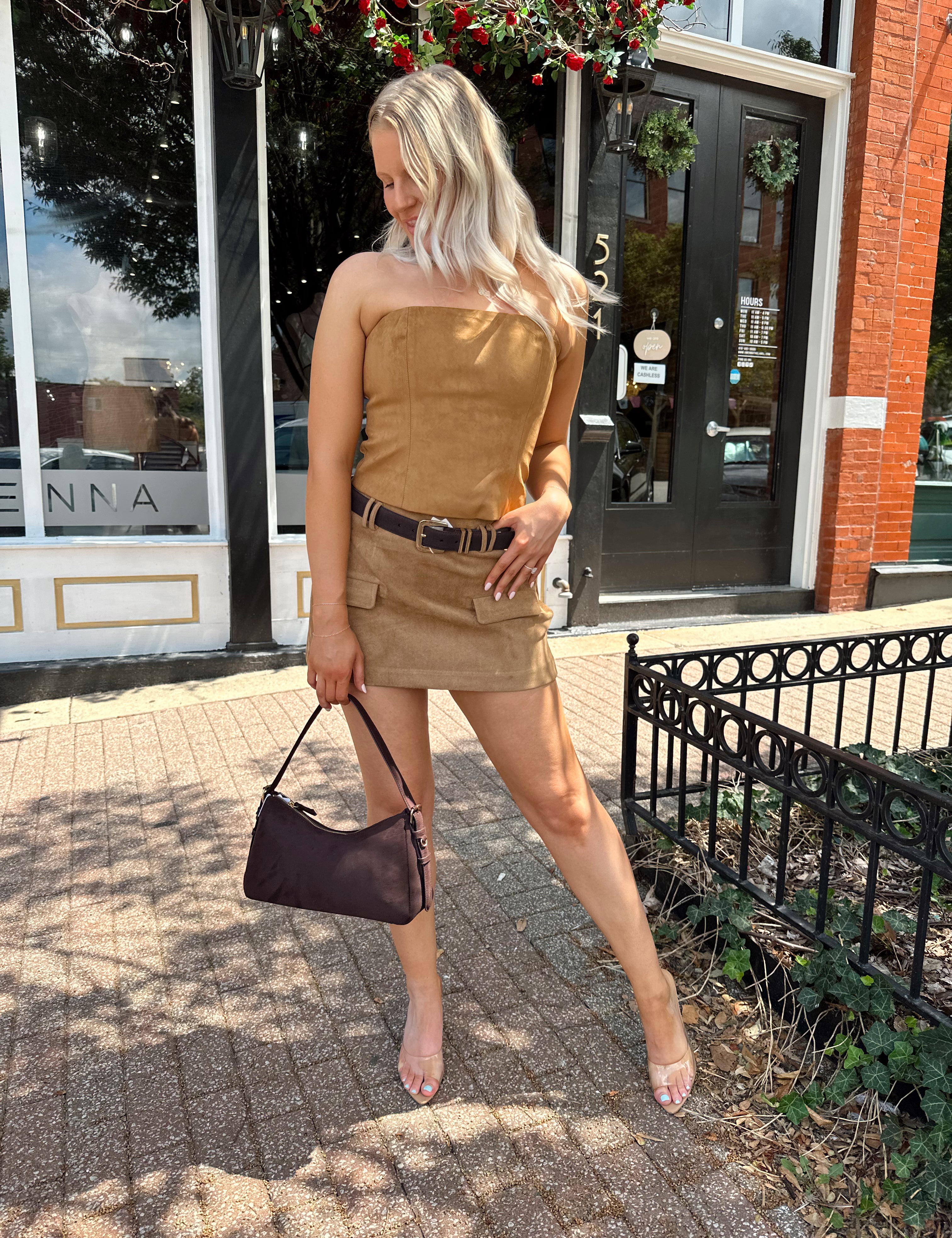 Woman wearing tan suede strapless corset top with suede mini skirt.