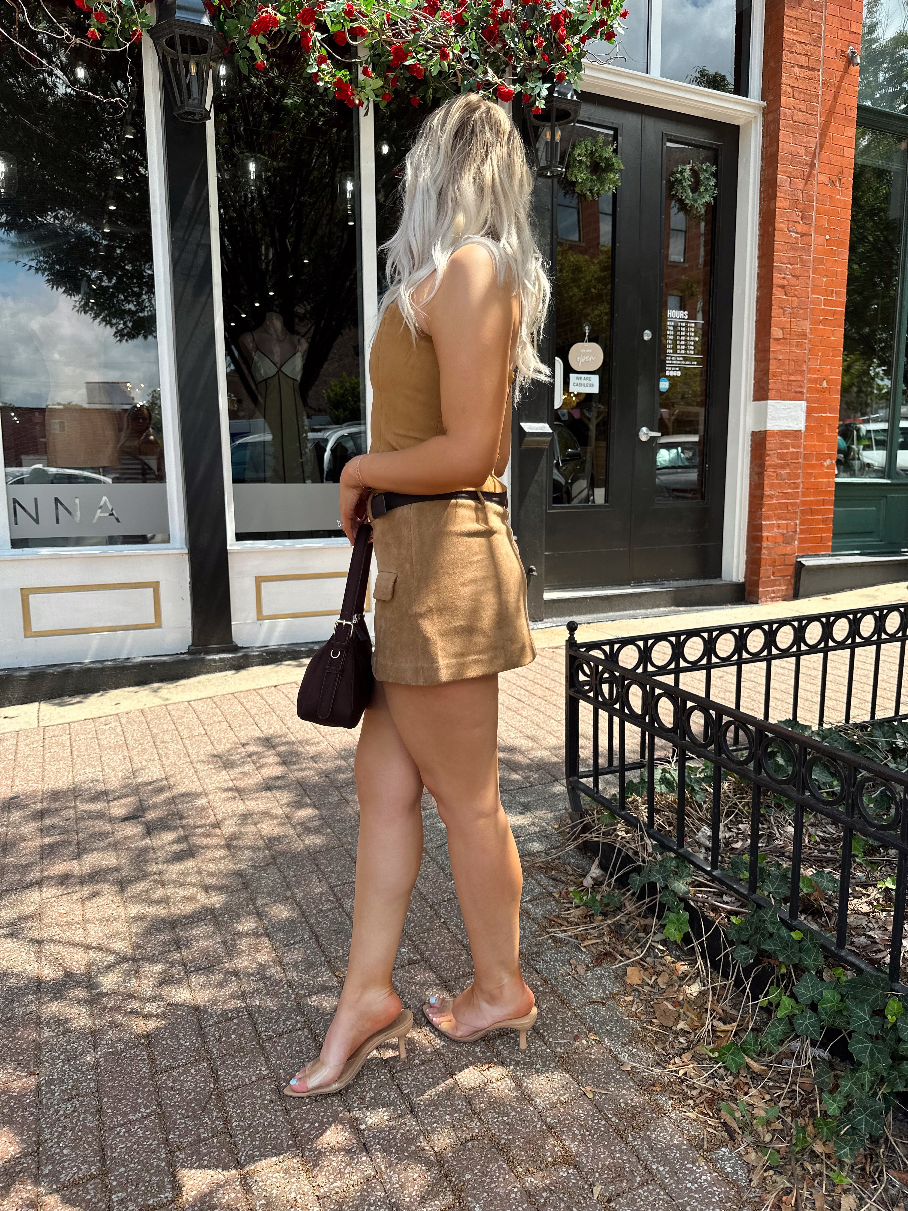 Woman wearing tan suede strapless corset top with suede mini skirt.