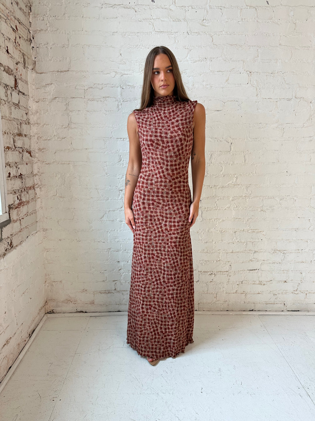 Woman wearing burgundy and brown textured dotted maxi dress.