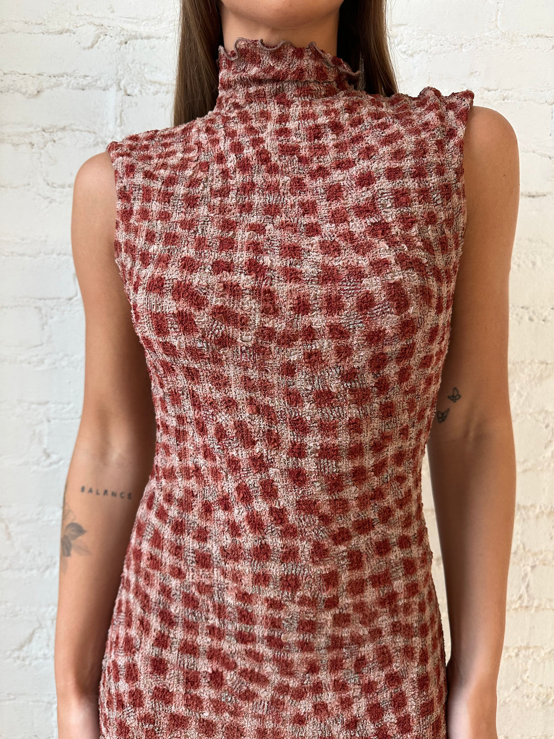 Woman wearing burgundy and brown textured dotted maxi dress.
