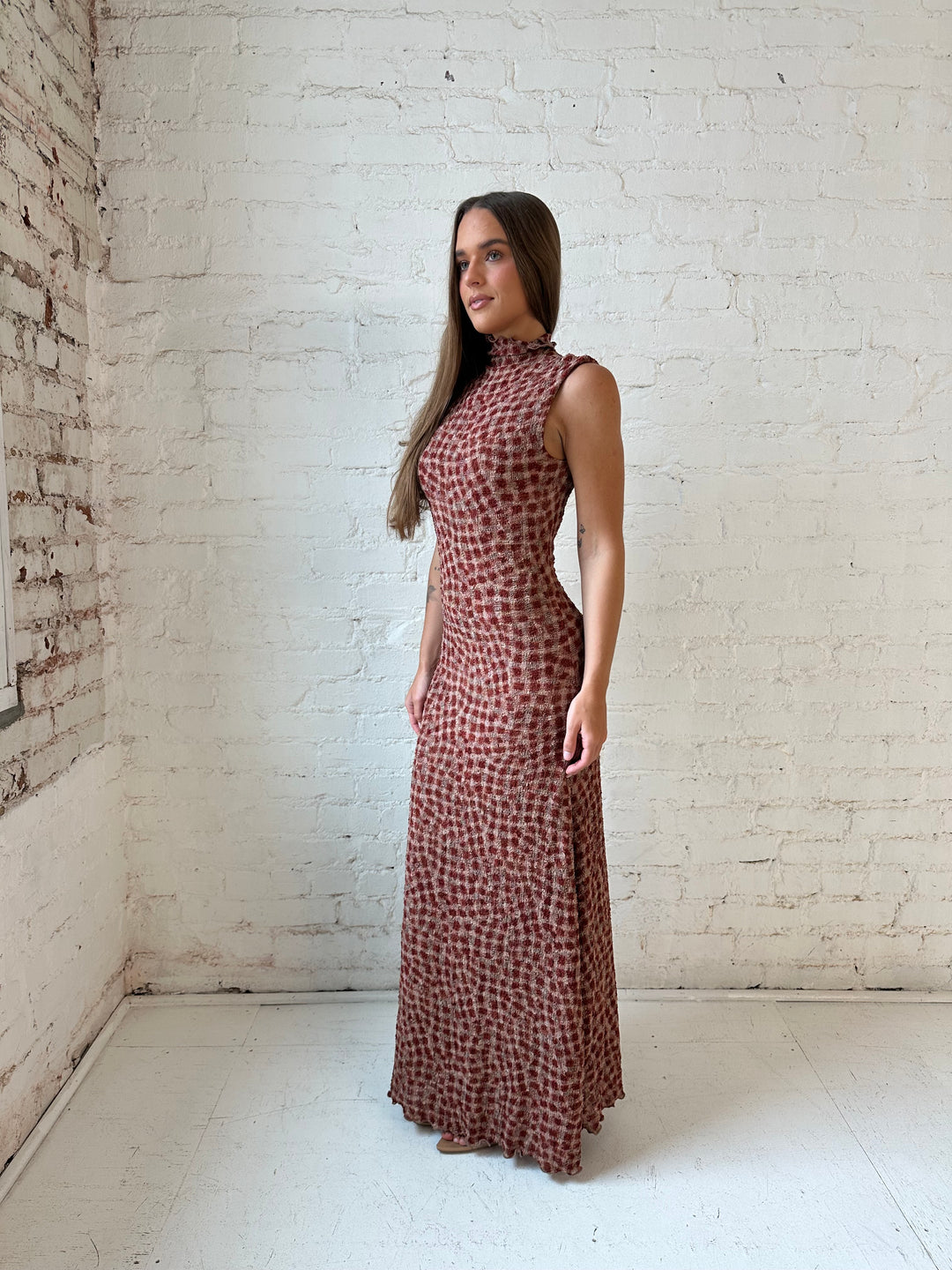 Woman wearing burgundy and brown textured dotted maxi dress.