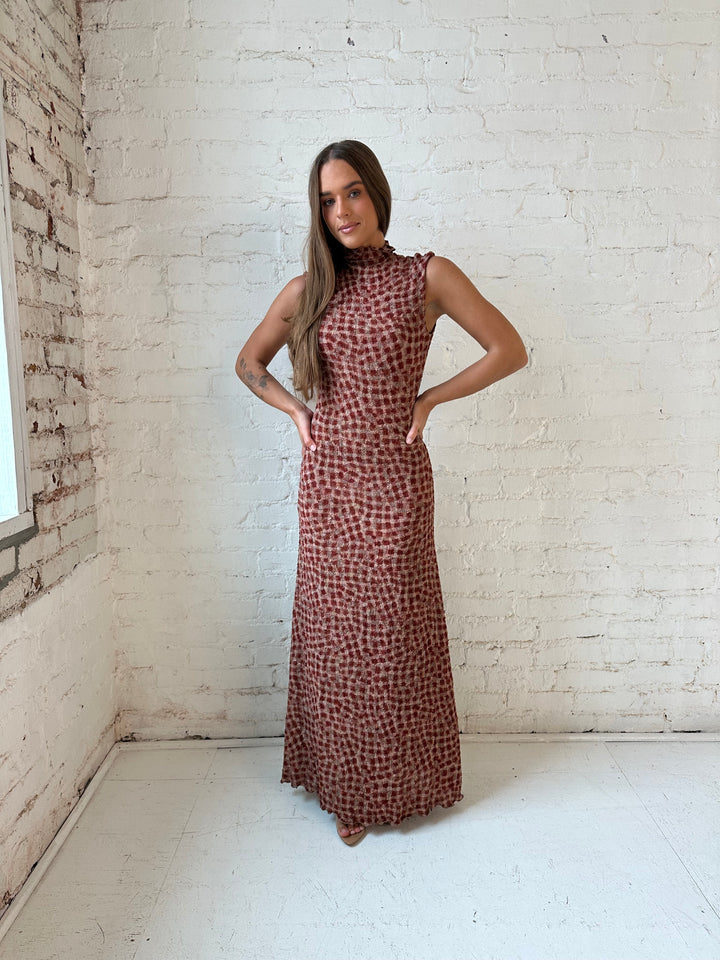 Woman wearing burgundy and brown textured dotted maxi dress.