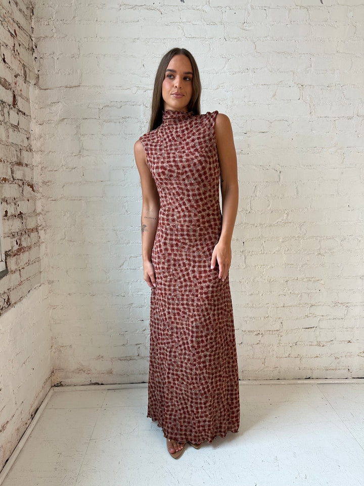 Woman wearing burgundy and brown textured dotted maxi dress.