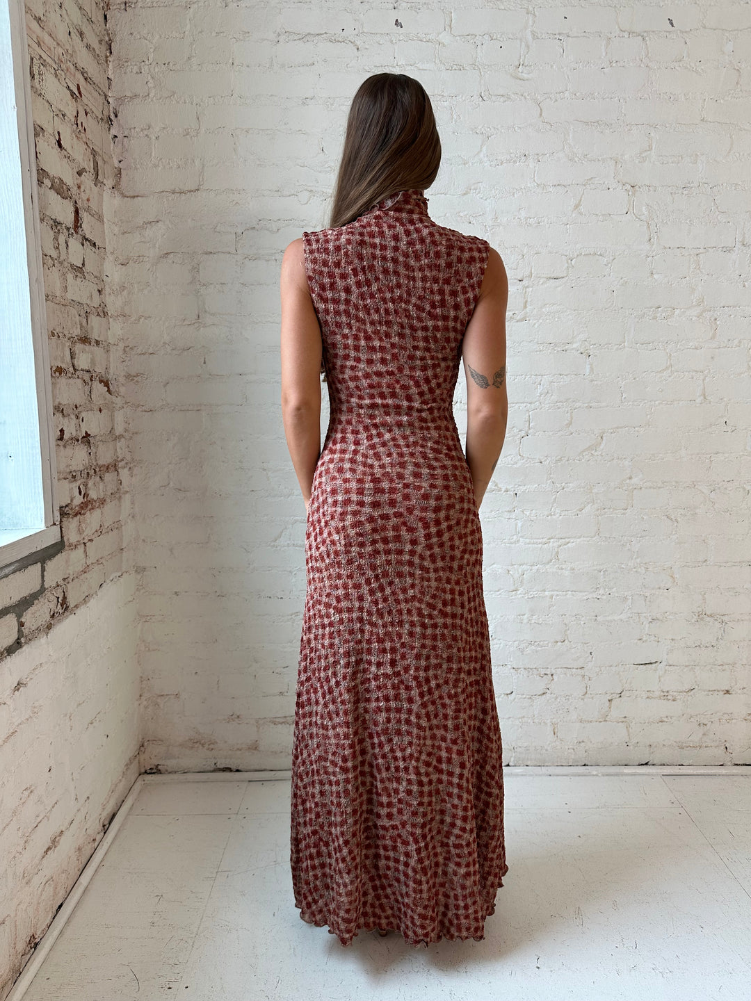 Woman wearing burgundy and brown textured dotted maxi dress.