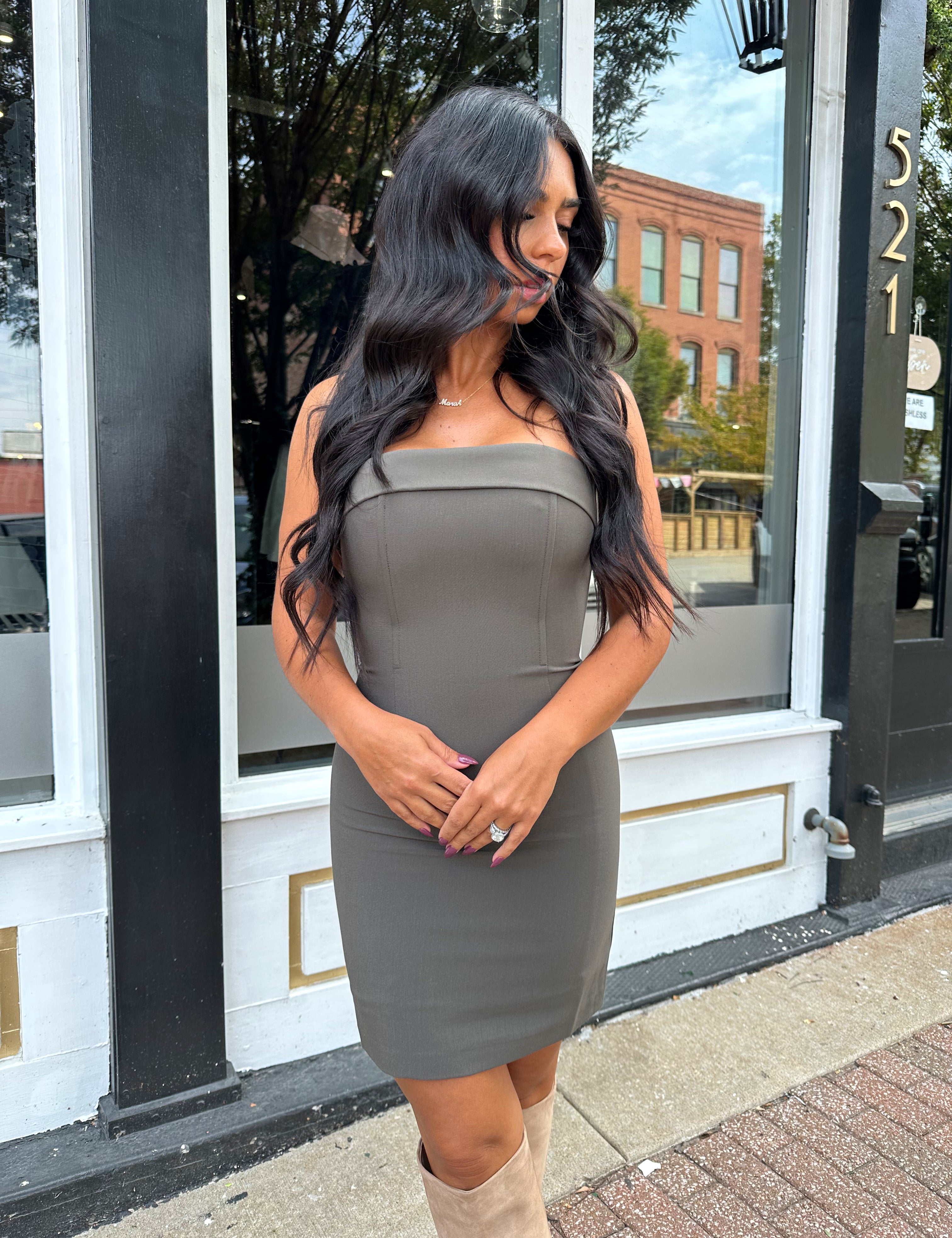 Woman wearing dark grey tailored strapless mini dress. 