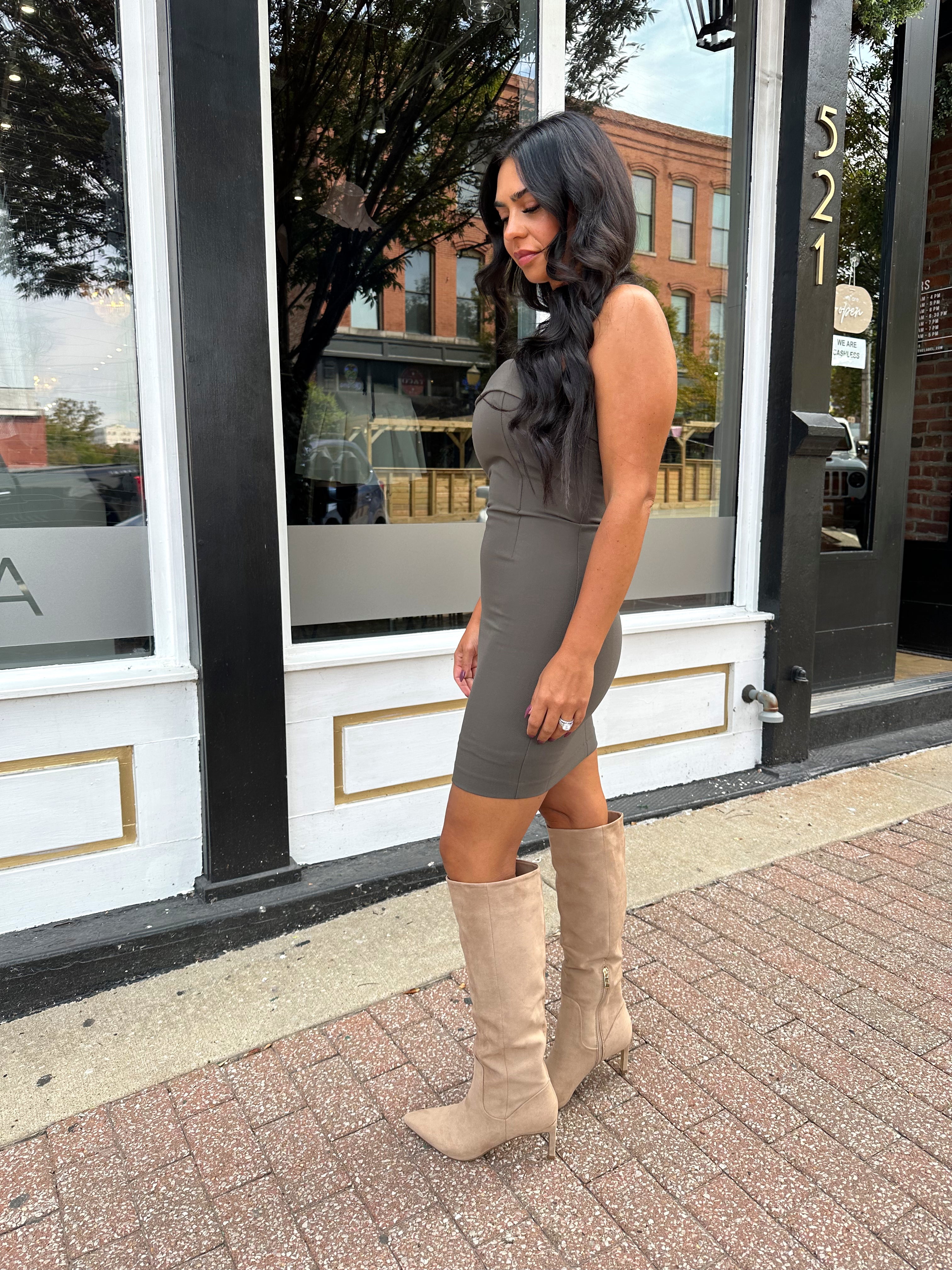 Woman wearing dark grey tailored strapless mini dress. 