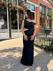Woman wearing black mesh maxi dress with side cutout, and off the shoulder asymmetrical neckline. 