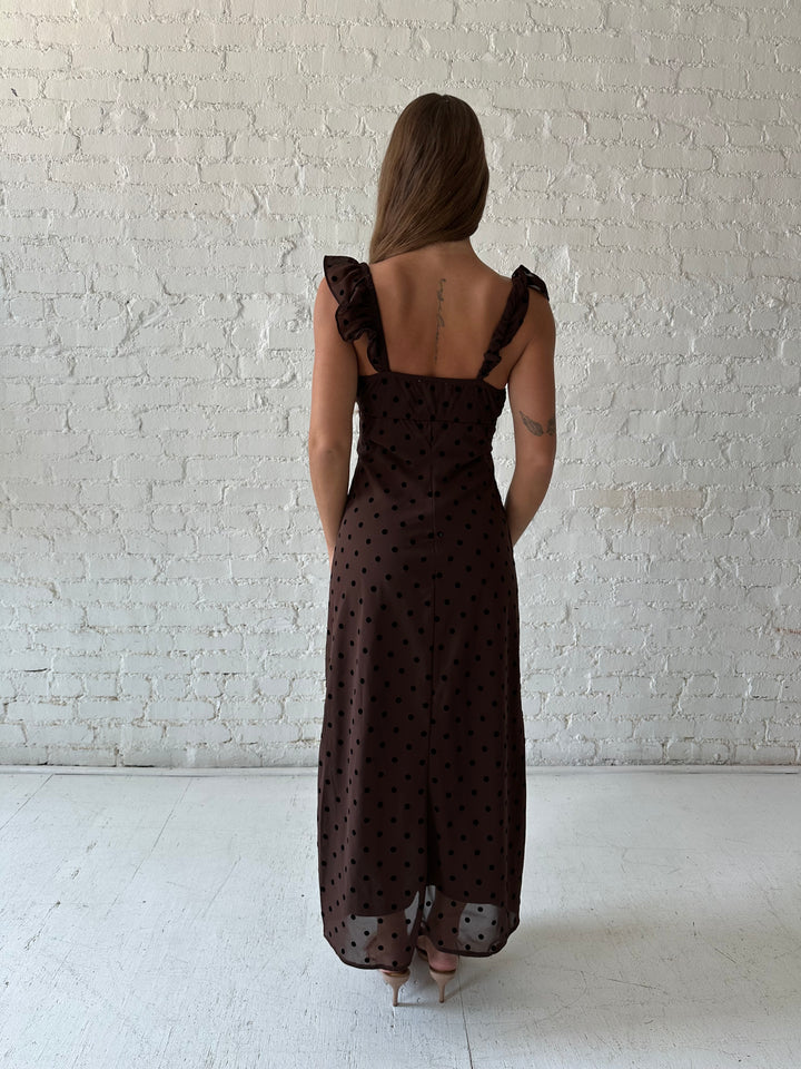 Woman wearing brown polka dot midi dress with ruffle straps.