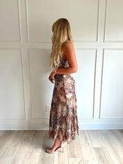 Woman wearing a leopard print maxi dress with adjustable spaghetti straps. 