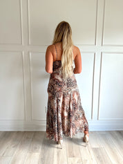 Woman wearing a leopard print maxi dress with adjustable spaghetti straps. 