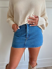 Medium wash denim mini skirt with functional pockets and belt loops.