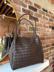 Dark brown vegan leather woven shoulder bag with braided straps and gold hardware. 