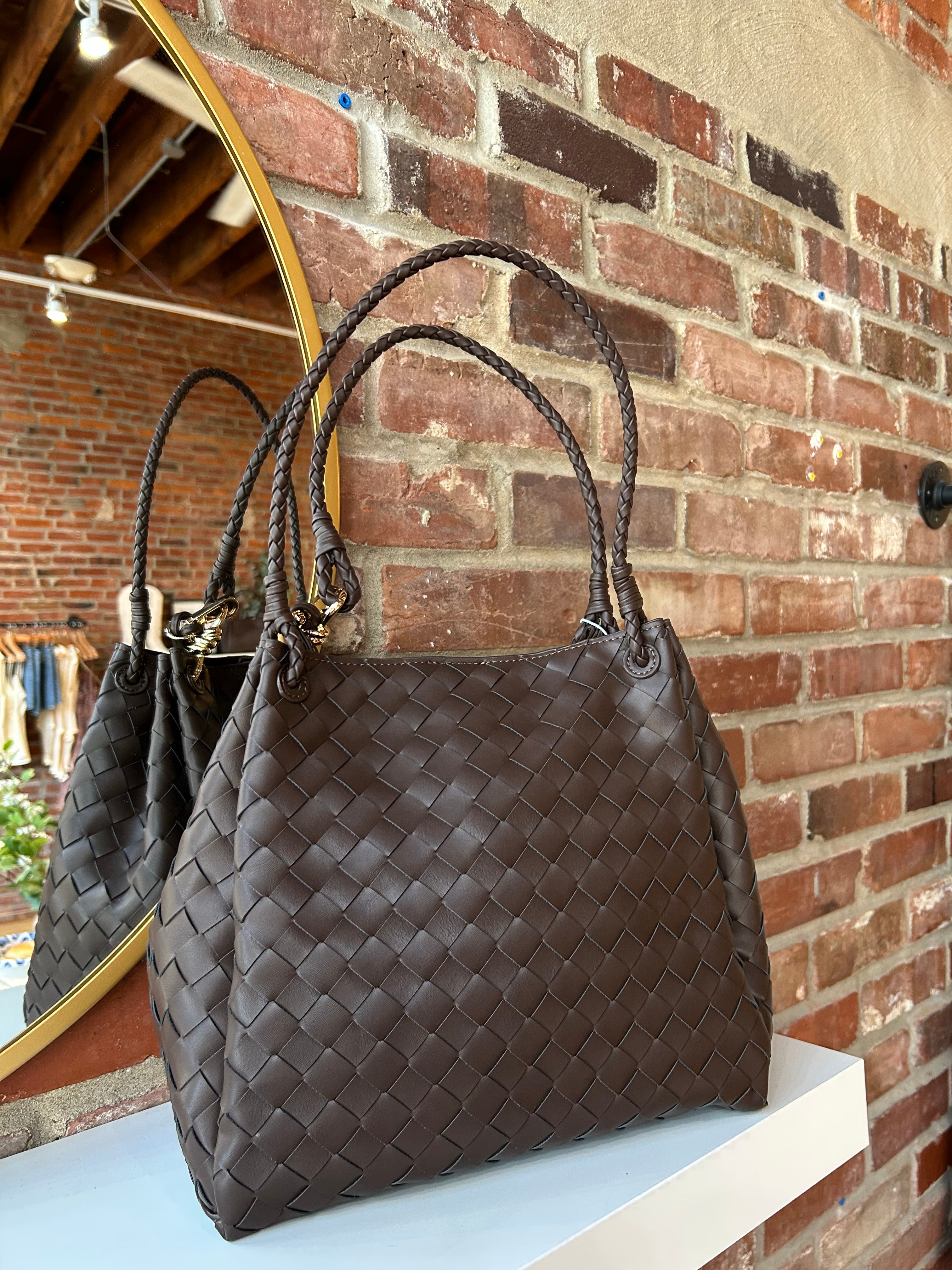 Dark brown vegan leather woven shoulder bag with braided straps and gold hardware. 