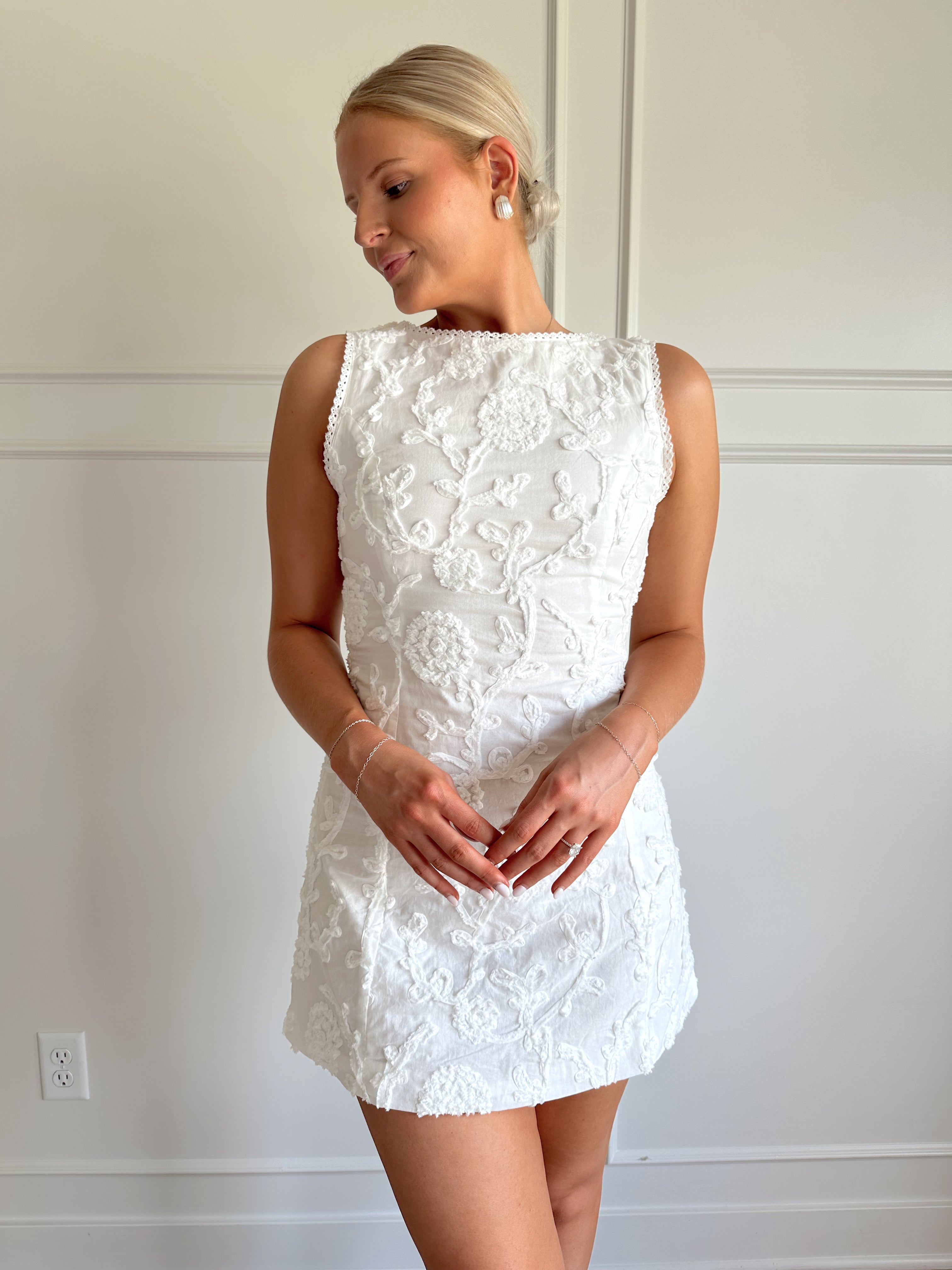 White a-line mini dress with floral jacquard pattern.