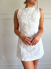 White a-line mini dress with floral jacquard pattern.